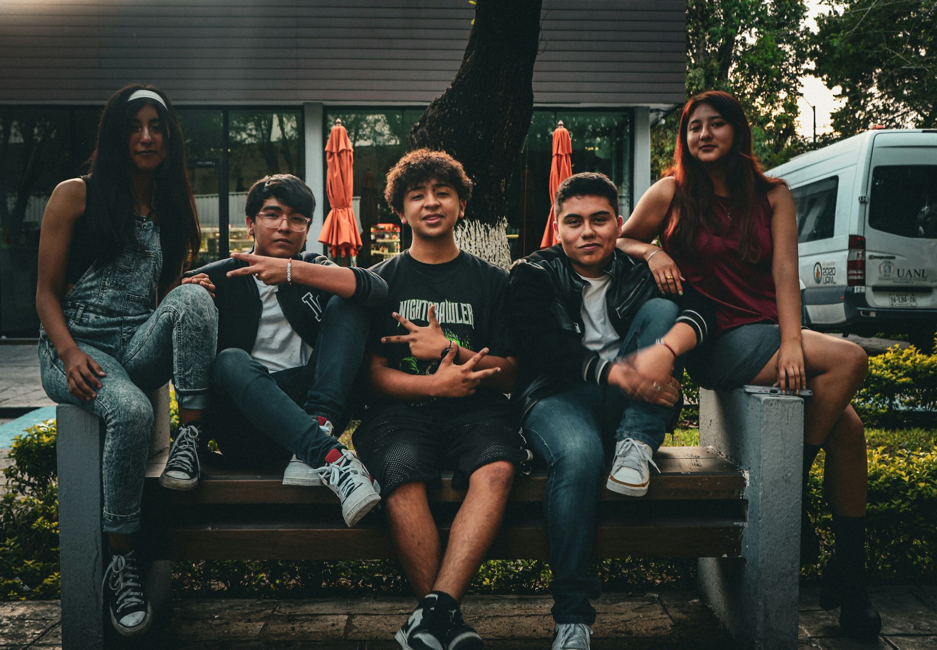 A group of people sitting on top of a wooden bench